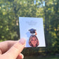 Custom graduation lapel pin with photo and graduation cap on a display card.