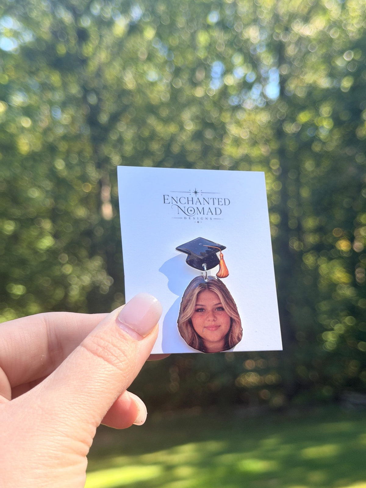 Custom graduation lapel pin with photo and graduation cap on a display card.