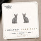 Gray Sphynx Cat Stud Earrings on the tilted Enchanted Nomad Designs card