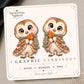 Autumn owl with a sage green scarf and orange leaf on the tilted Enchanted Nomad Designs display card