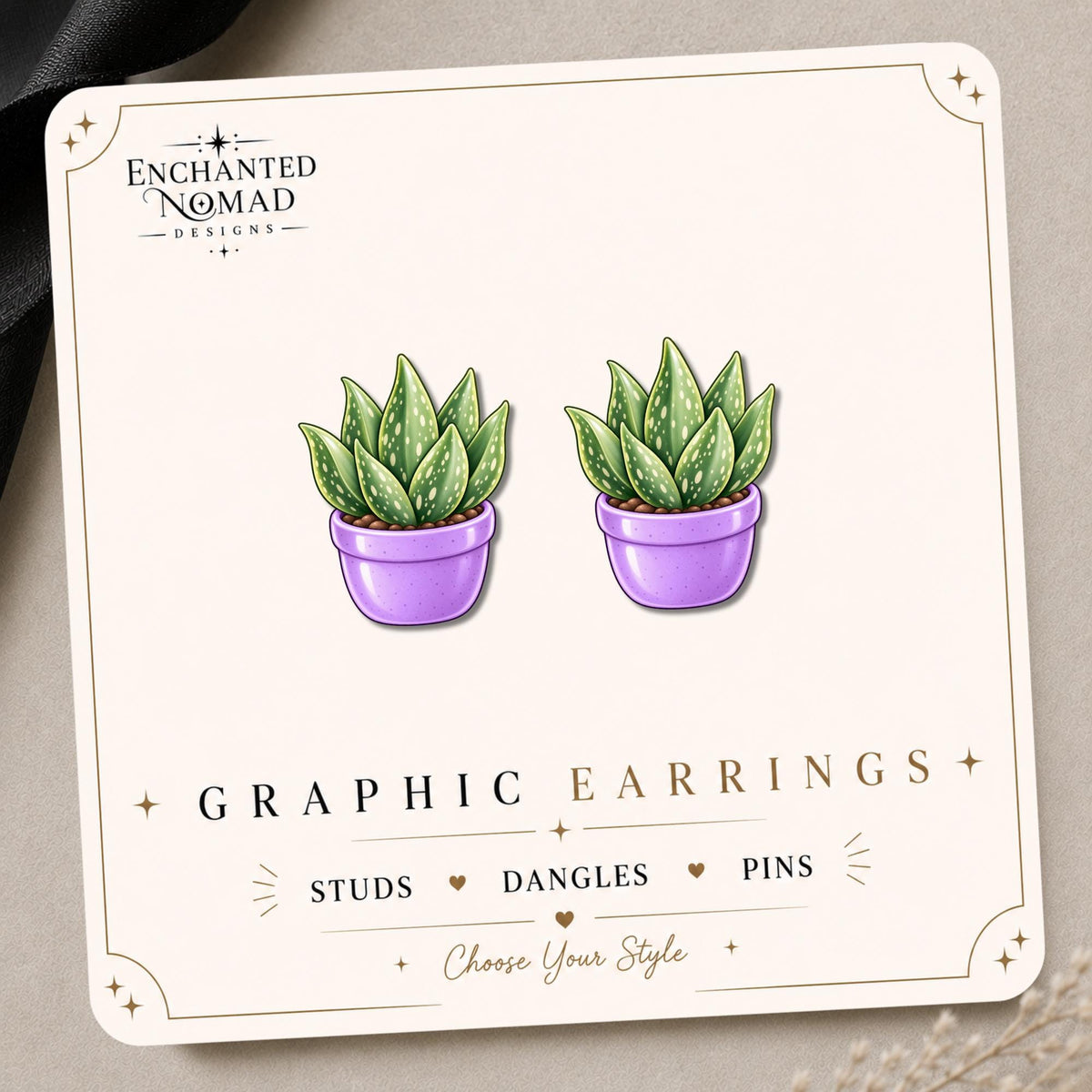 Aloe Vera graphic earrings and pins on a display card