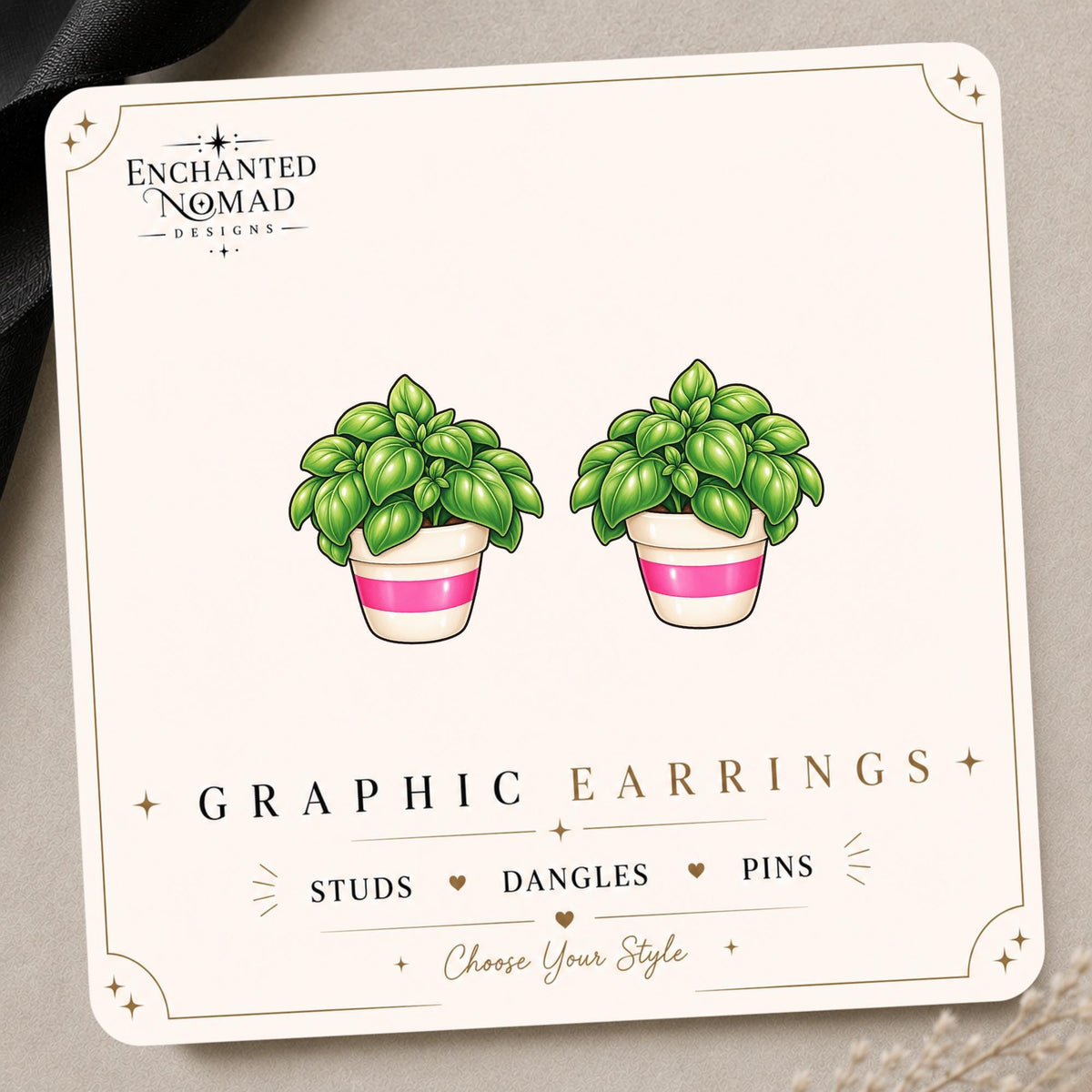 Basil Plant graphic earrings and pins on a display card