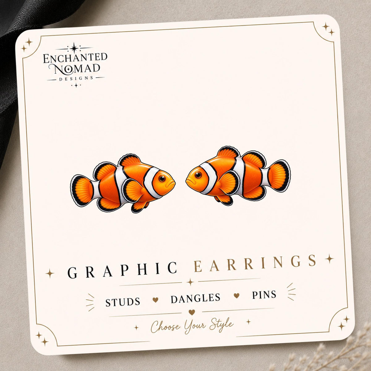 Clownfish graphic earrings and pins on a display card