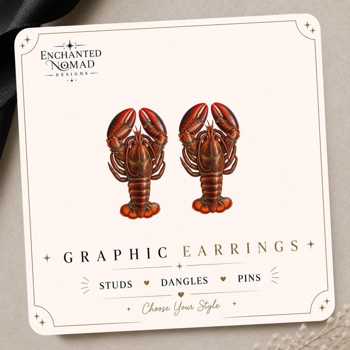 Lobster graphic earrings and pins on a display card