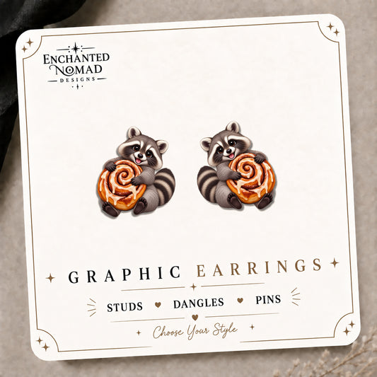 Raccoon Cinnamon Roll Stud Earrings on the tilted Enchanted Nomad Designs card