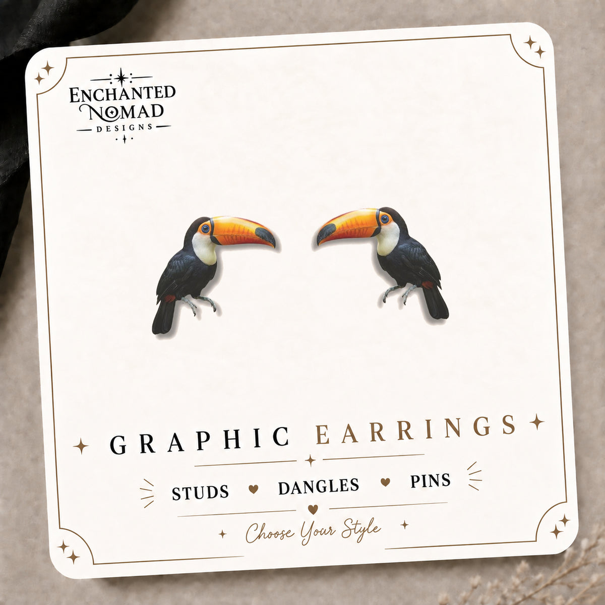 Toucan Earrings & Pins on the tilted Enchanted Nomad Designs card